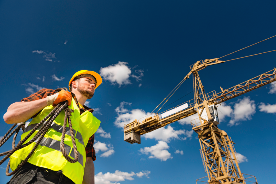 Construction worker with cable under the tower crane Bild: Microgen/stock.adobe.com