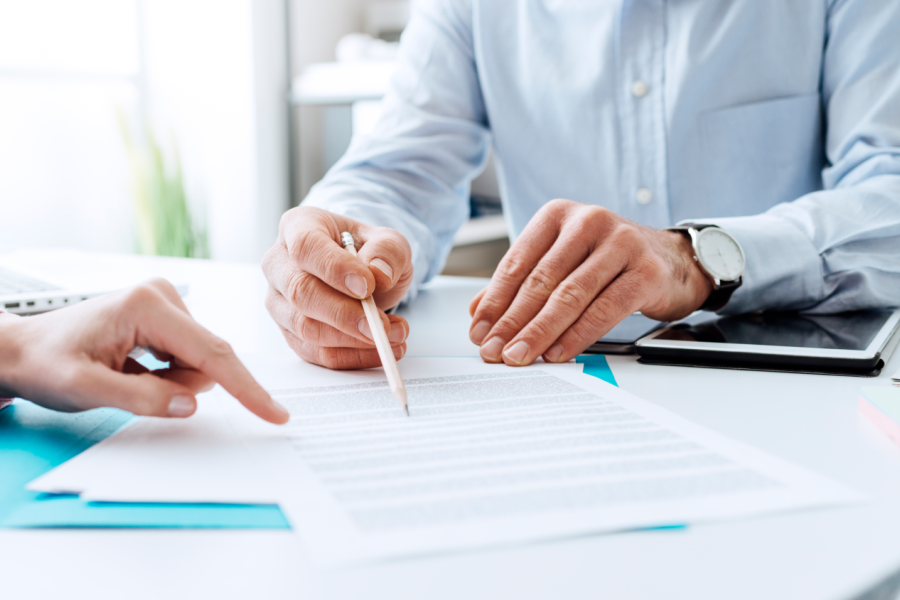 Business people negotiating a contract, they are pointing on a document and discussing together Bild: de.stock.adobe.com/StockPhotoPro 