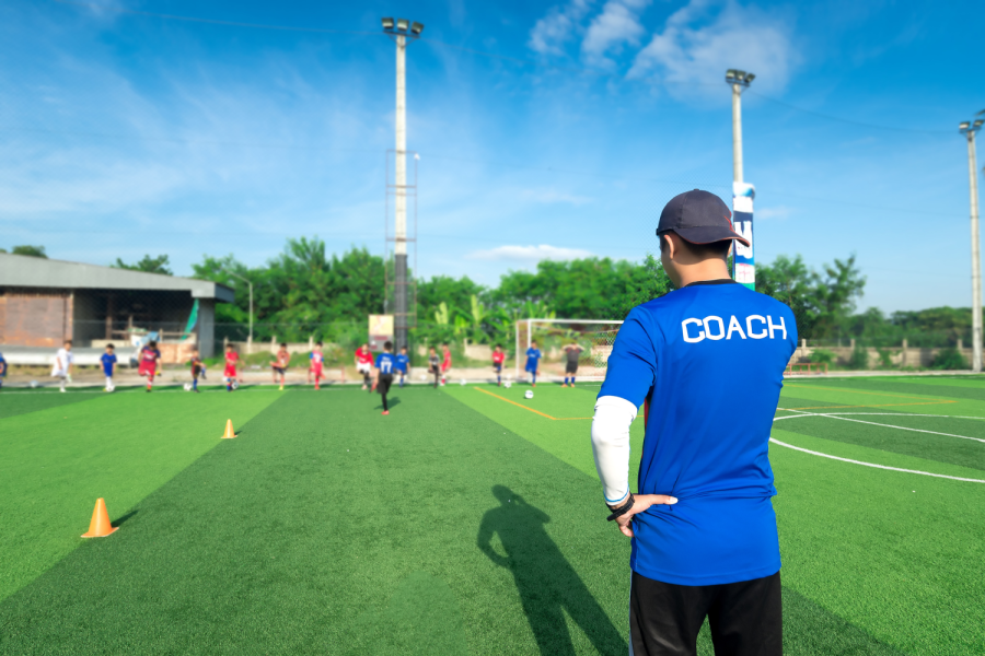 blurred image of Coach is coaching Children Training In Soccer Team Bild: de.stock.adobe.com/pongsakorn_jun26