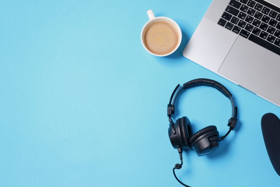 Music or podcast background with headphones, microphone, coffee and laptop on blue table, flat lay. Top view, flat lay Bild: Boyarkina Marina/stock.adobe.com