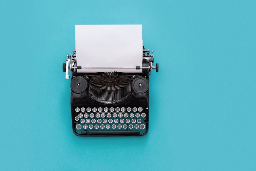 Vintage typewriter over blue background with copy space Bild: rangizzz/stock.adobe.com