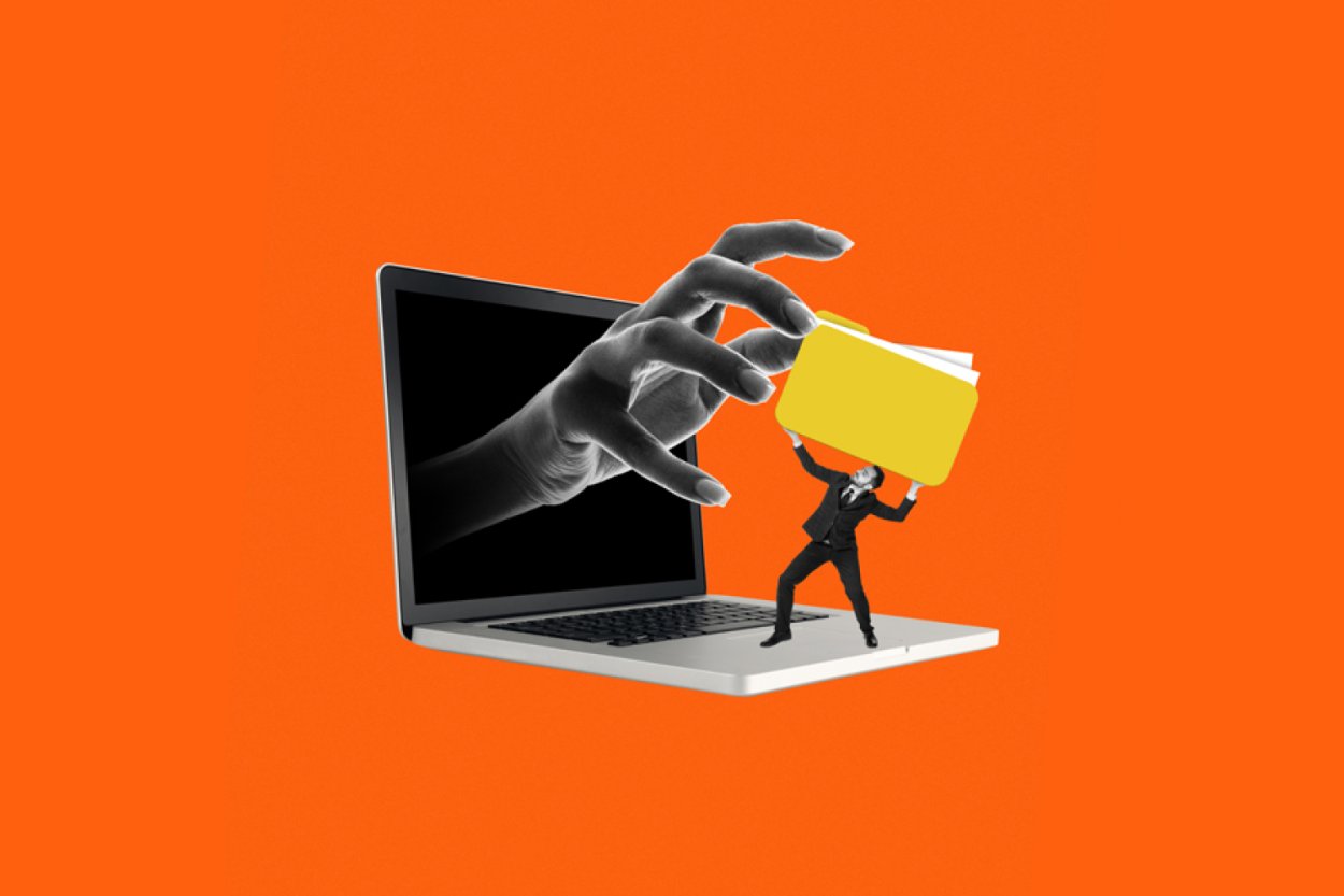 Hand greift einen Geldbeutel aus einem Laptop heraus